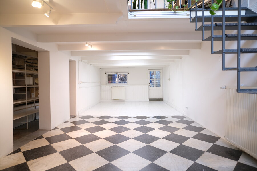 Lower-level white room at COSMOS152 with checkerboard floor and stairs