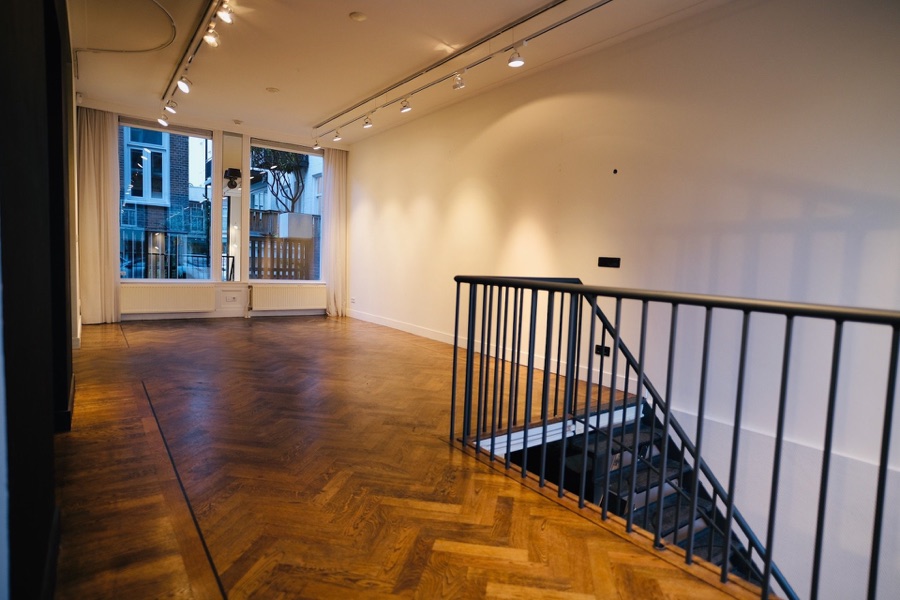 Wide open event space with herringbone floor and staircase at COSMOS152