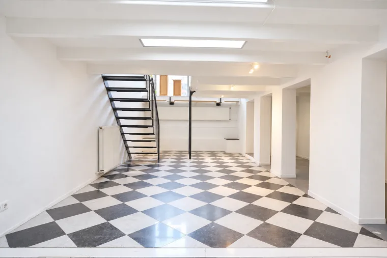 Long finished impression through the empty basement beneath its low white beams