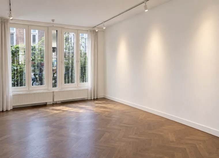 Finished impression of the empty herringbone-floor room with tall windows