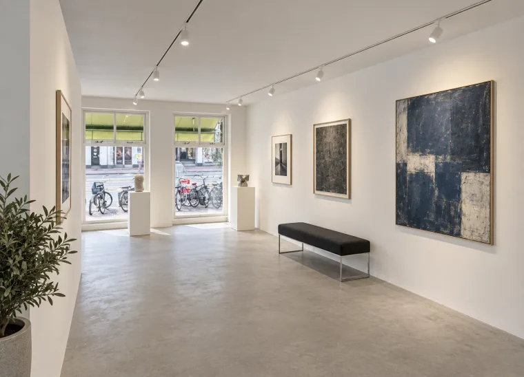 Furnishing impression of an exhibition with artwork, plinths and a gallery bench