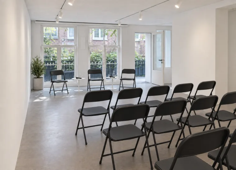 Furnishing impression of a panel discussion with black chairs for speakers and audience